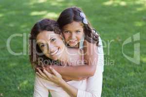 Happy mother and daughter smiling at camera