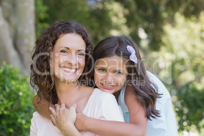 Happy mother and daughter smiling at camera