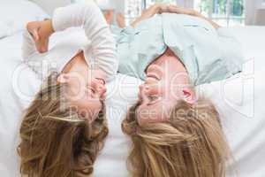 Mother and daughter lying on the bed