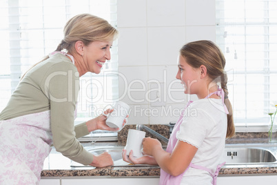 Mother and daughter washing up together