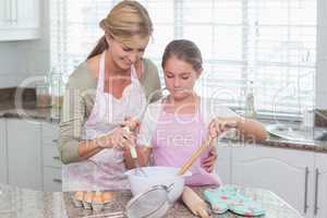 Mother and daughter making cake together