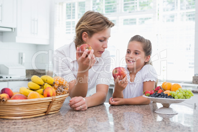 Mother and daughter holding apples