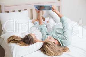 Happy mother and daughter using tablet