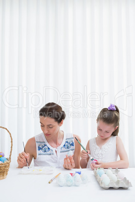 Mother and daughter painting easter eggs
