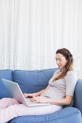 Casual woman using laptop on couch