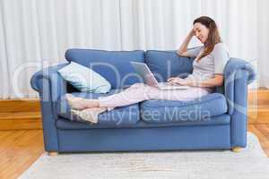 Casual woman using laptop on couch