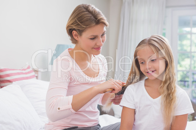 Mother brushing her daughters hair