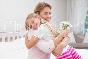 Mother and daughter hugging with flowers