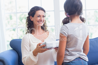 Cute girl offering gift to her mother