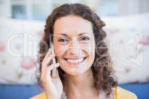 Pretty brunette sitting on the floor and speaking on the phone