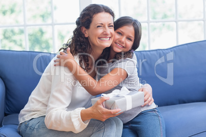 Happy mother and daughter hugging and smiling at camera