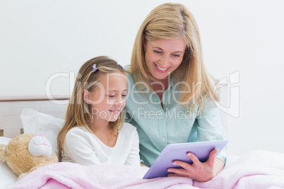 Happy mother and daughter using tablet