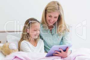 Happy mother and daughter using tablet