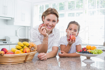 Mother and daughter holding apples