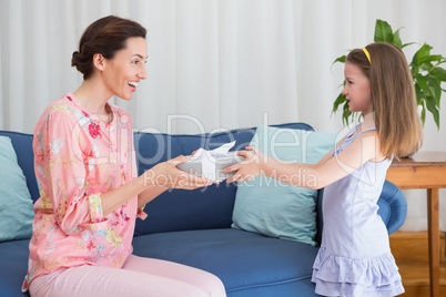 Little girl giving her mother a gift