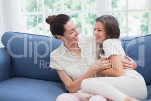 Mother and daughter laughing on couch