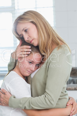 Sad little girl hugging her mother