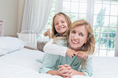 Happy mother and daughter smiling at camera