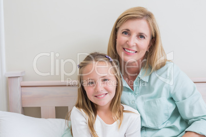 Happy mother and daughter smiling at camera