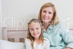 Happy mother and daughter smiling at camera