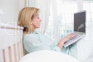 Focus woman using laptop in her bed