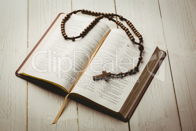 Open bible and wooden rosary beads