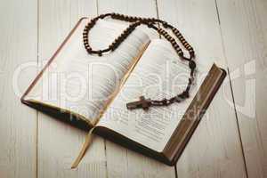 Open bible and wooden rosary beads