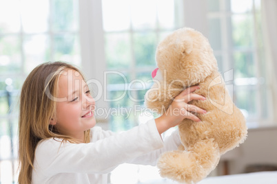 Happy little girl holding her teddy