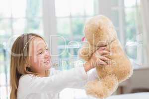 Happy little girl holding her teddy