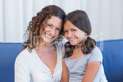 Happy mother and daughter smiling at camera