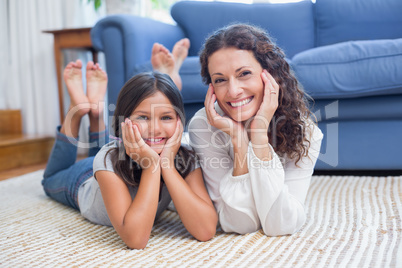 Happy mother and daughter lying on the floor