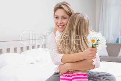 Mother and daughter hugging with flowers