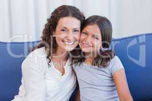 Happy mother and daughter smiling at camera