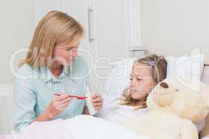 Mother giving her daughter cough medicine