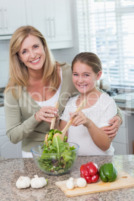 Mother and daughter preparing salad together