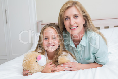 Happy mother and daughter smiling at camera