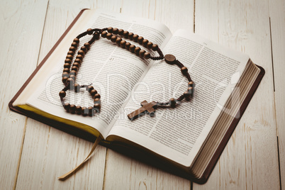 Open bible and wooden rosary beads