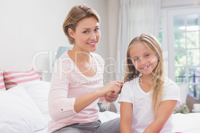 Mother brushing her daughters hair