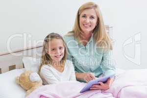 Happy mother and daughter using tablet