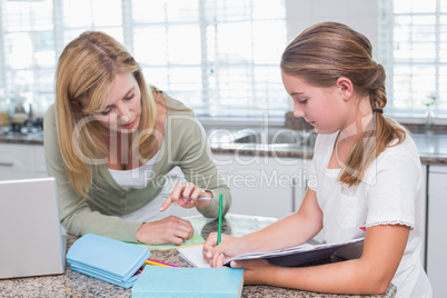 Mother helping daughter doing homework