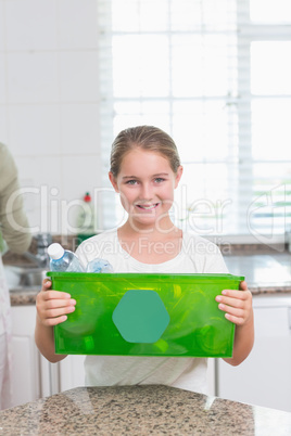 Happy little girl holding recycling box