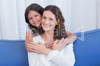 Happy mother and daughter smiling at camera