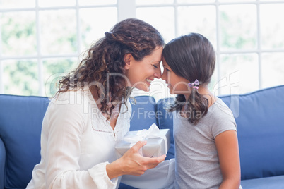 Cute girl offering gift to her mother