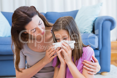 Mother helping daughter blow her nose