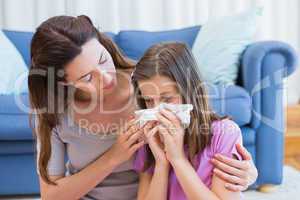 Mother helping daughter blow her nose