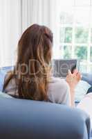 Casual woman using tablet on couch