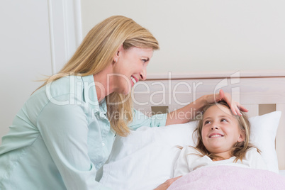 Happy mother and daughter smiling at each other