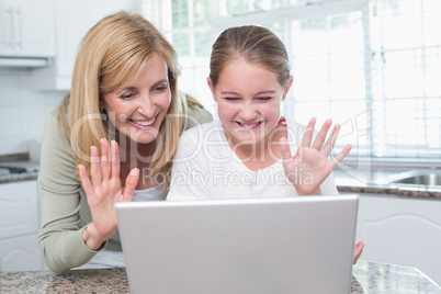 Mother and daughter talking with someone with the laptop