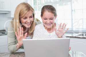 Mother and daughter talking with someone with the laptop