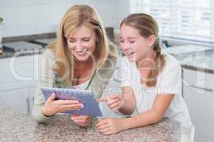 Happy mother and daughter using tablet pc together